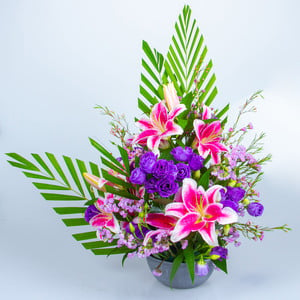 Facing Table Arrangement With Lilies, Eustoma, Wax Flower And Statics