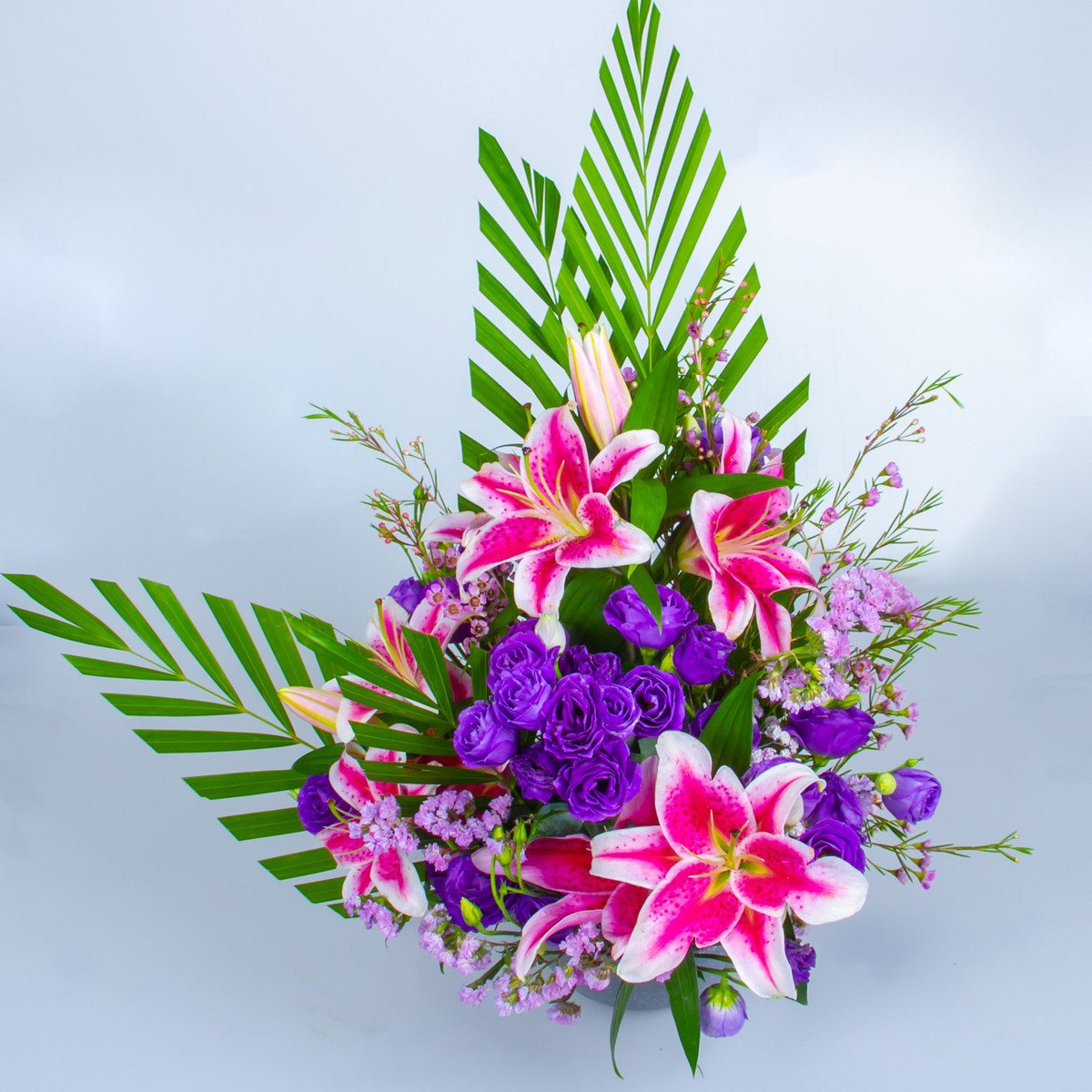 Facing Table Arrangement With Lilies, Eustoma, Wax Flower And Statics